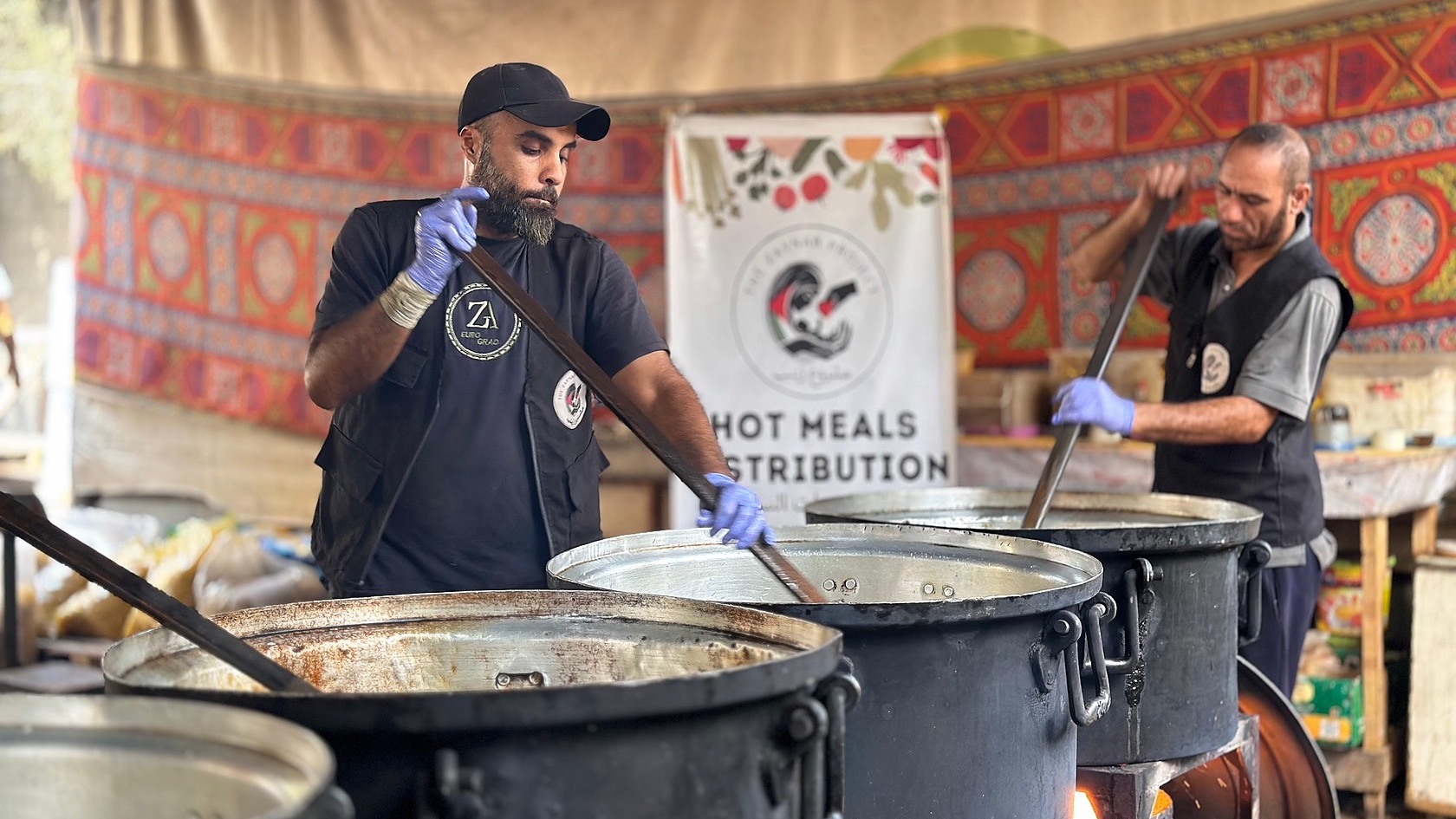 Members of the Zaynab Project ground team preparing food at large cooking pots